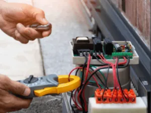 un operatore ripara i fili di un cancello automatico