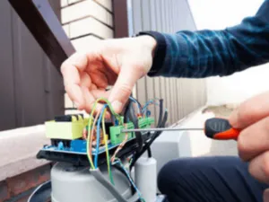 un operatore ripara i fili di un cancello automatico